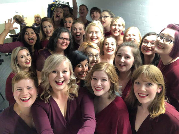A backstage selfie of Steel City Voices in our red performance dresses